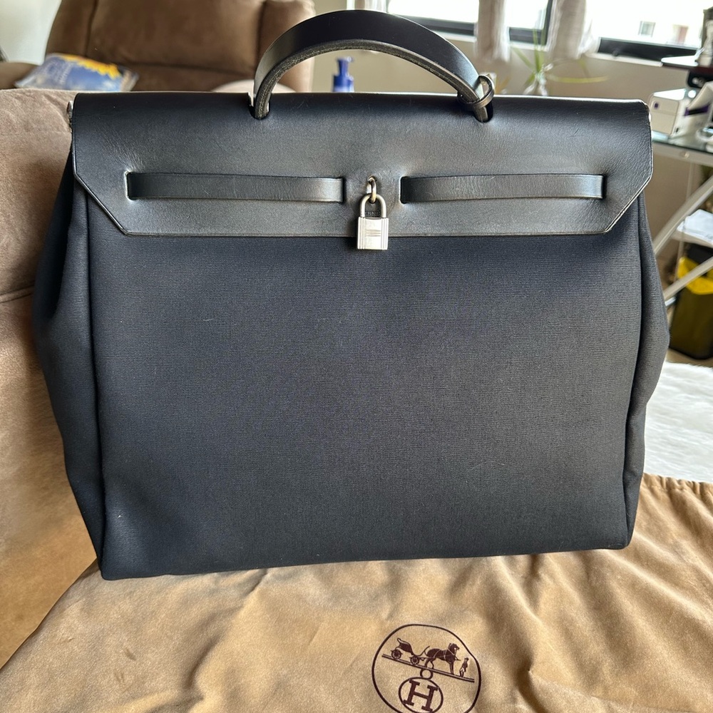 Elegant Black Satchel with Top Handle and Padlock Accent